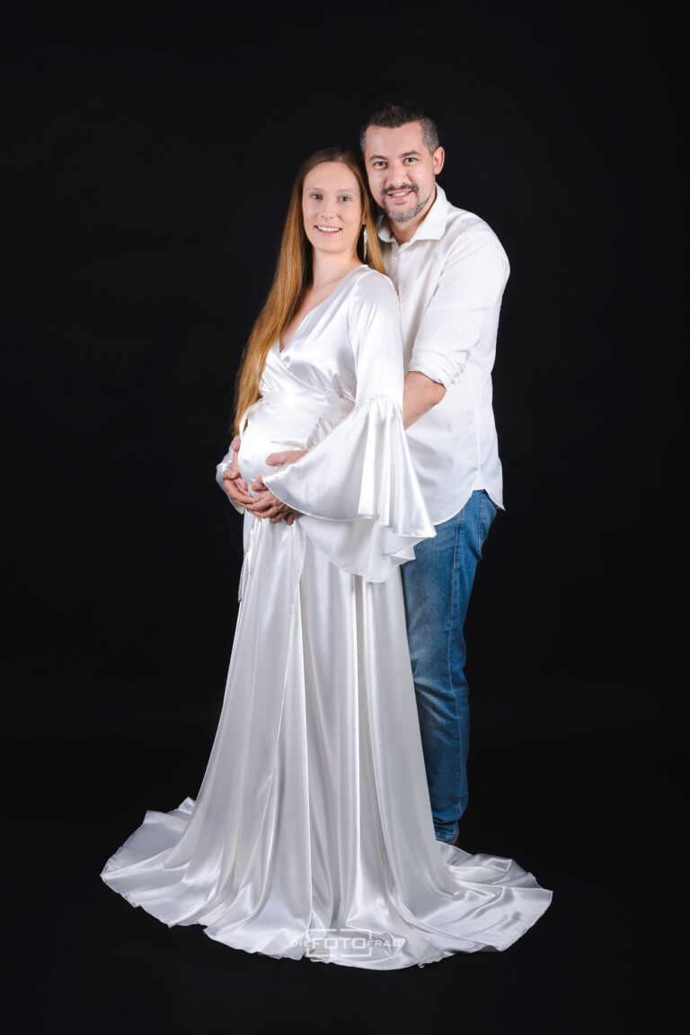 Babybauchshooting mit Partner im Fotostudio mit weißem Satinkleid
