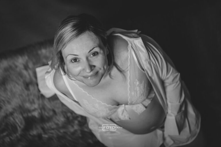 Babybauchshooting in Schwarzweiss mit Blick von oben auf die Mutter, die Dessous trägt