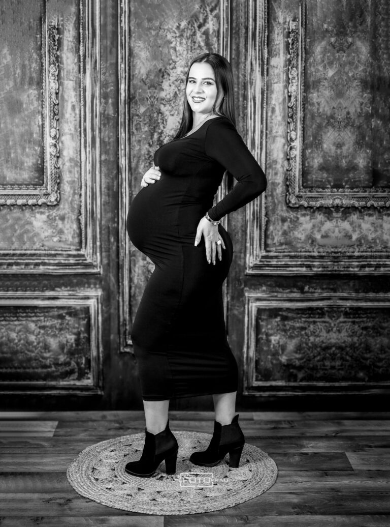Babybauchshooting vor einer Kulisse einer Schlossmauer, die werdende Mutter trägt ein schwarzes Kleid