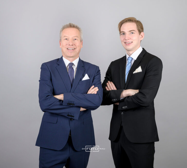 Businessportrait von 2 Unternehmensberatern im Anzug vor grauem Hintergrund im Fotostudio Linz