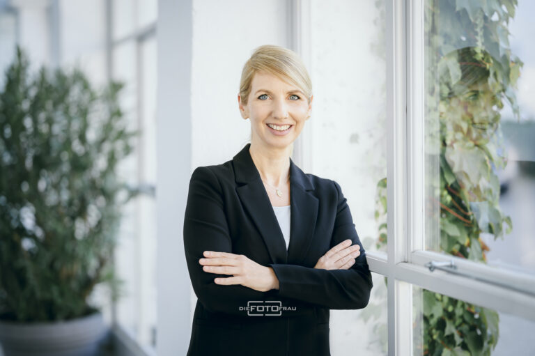 Businessportrait einer Dame im Businesskostuem vor einer Fensterfront in einem Schloss