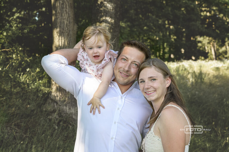 Familienfoto mit spielender Tochter im Garten