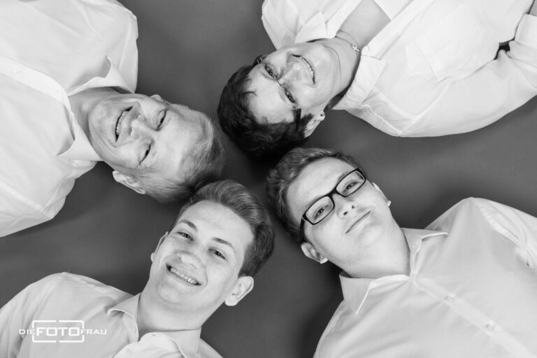 Familienfoto im Fotostudio Linz, das Bild zeigt nur die Köpfe von oben, schwarzweiss