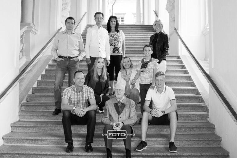 Familienfoto in schwarzweiss, die Familie steht und sitzt auf einer Kirchentreppe