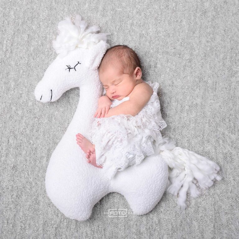 Neugeborenenfotografie mit schlafendem Baby auf einem Stoffalpaka