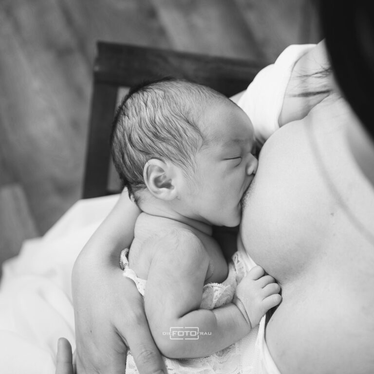 Neugeborenenfoto, die Mutter stillt das Baby, schwarzweiss