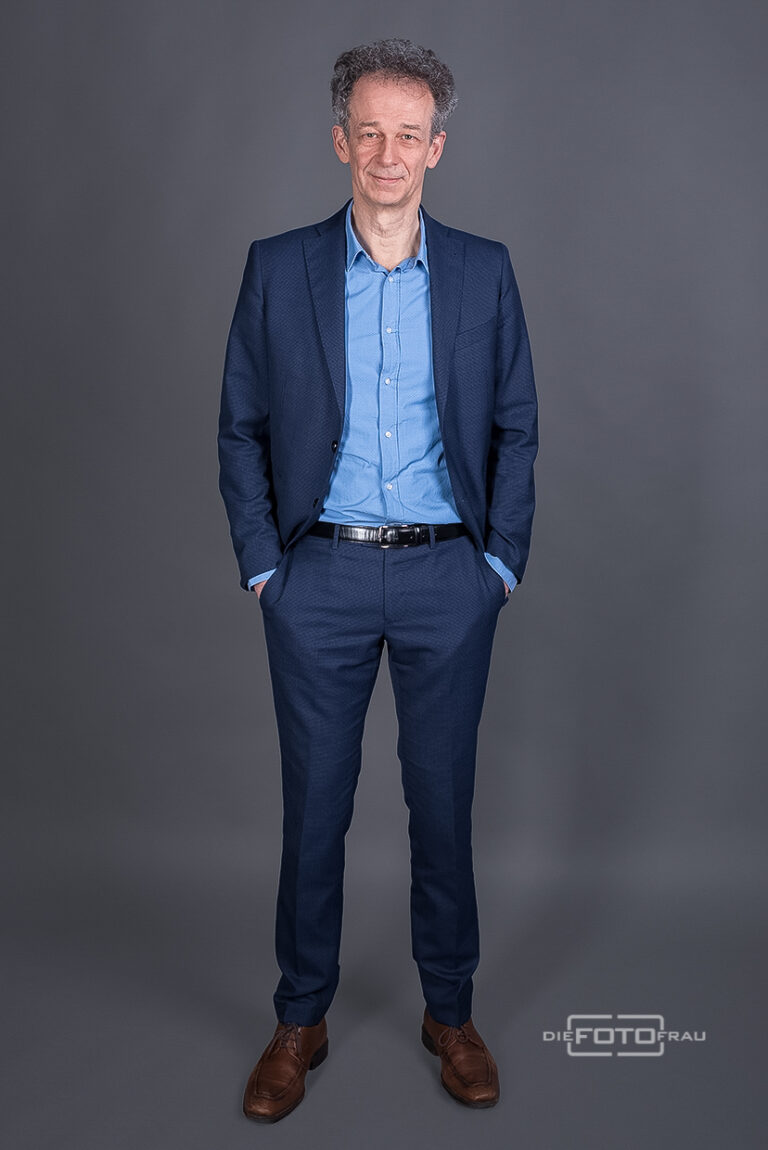 Portraitfoto eines Arztes im Fotostudio Linz, der Herr trägt einen blauen Anzug