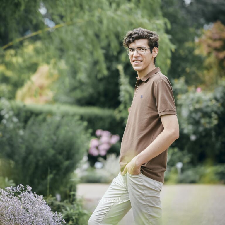 Portraitfoto eines jungen Mediziners in Freizeitkleidung im Botanischen Garten in Linz