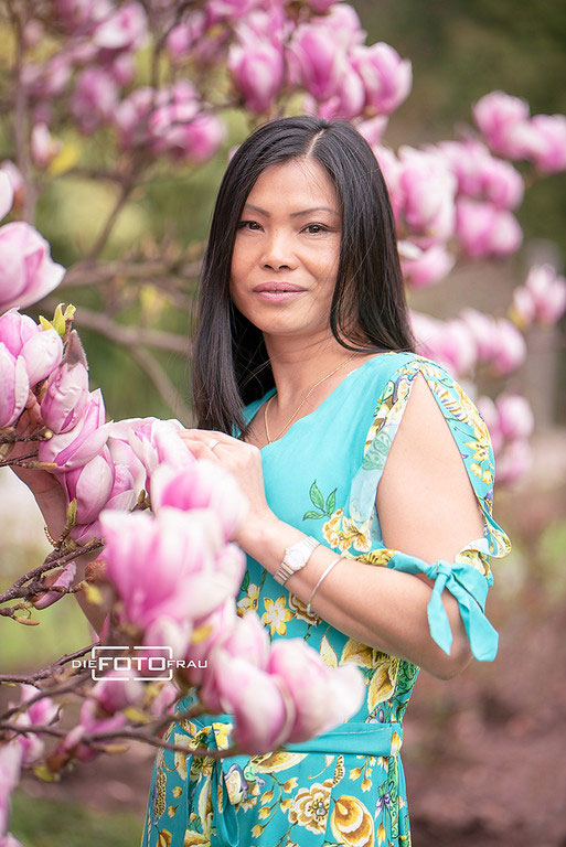 Portraitfoto einer Vietnamesin vor einer Magnolie im Botanischen Garten Linz