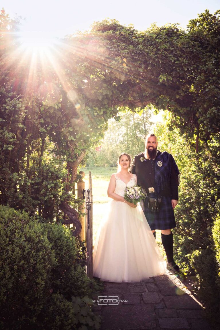 Bräutigam im Kilt und Braut im Sonnenuntergang beim Brautpaarshooting