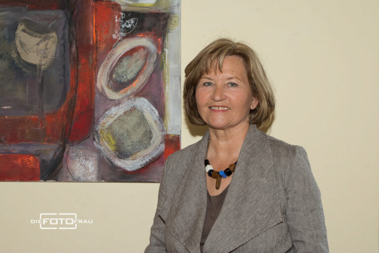 Portrait einer Malerin vor einem Bild in einem Museum