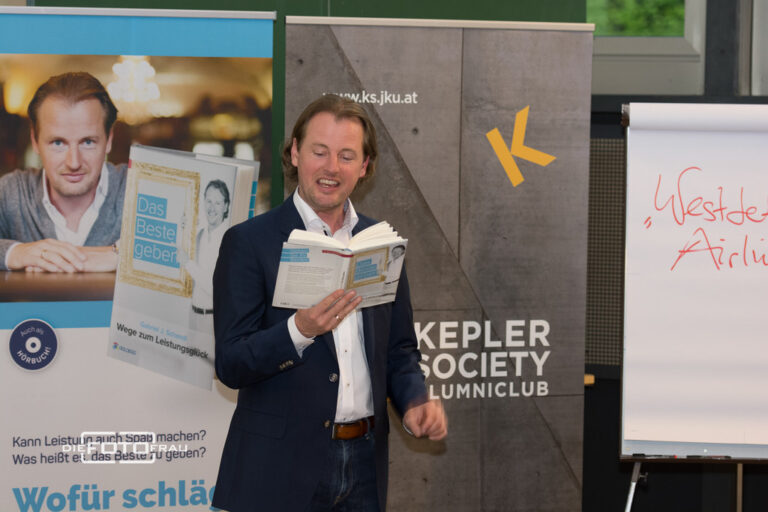 Mann der aus einem Buch liest in einem Hörsaal einer Universität