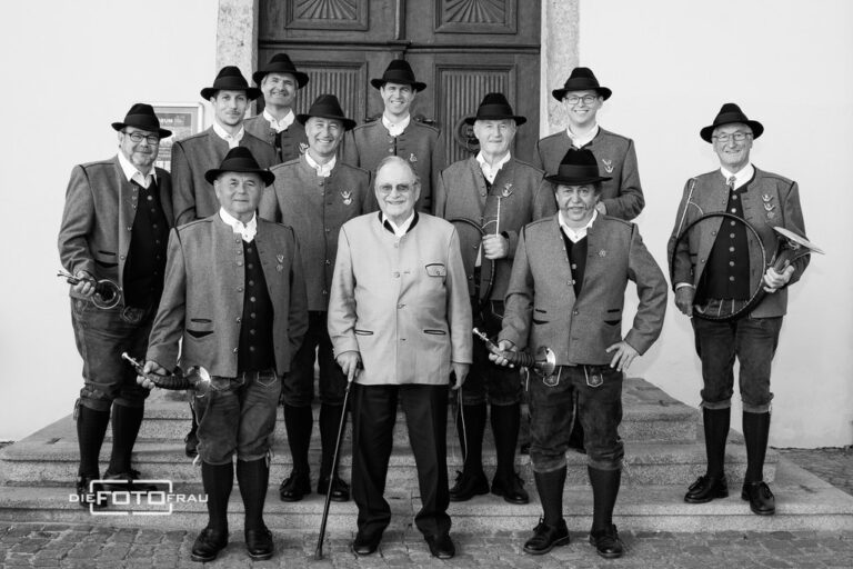 Männer in Trachtenanzügen vor Schloss, schwarzweiss