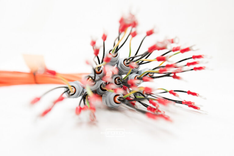 bunte Kabel mit Steckern in scharfer und unscharfer Form aufgenommen, weisser Hintergrund