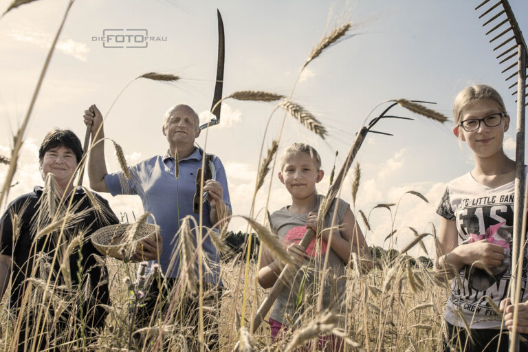 Bauersfamilie mit Kindern im Getreidefeld bei Abendsonne