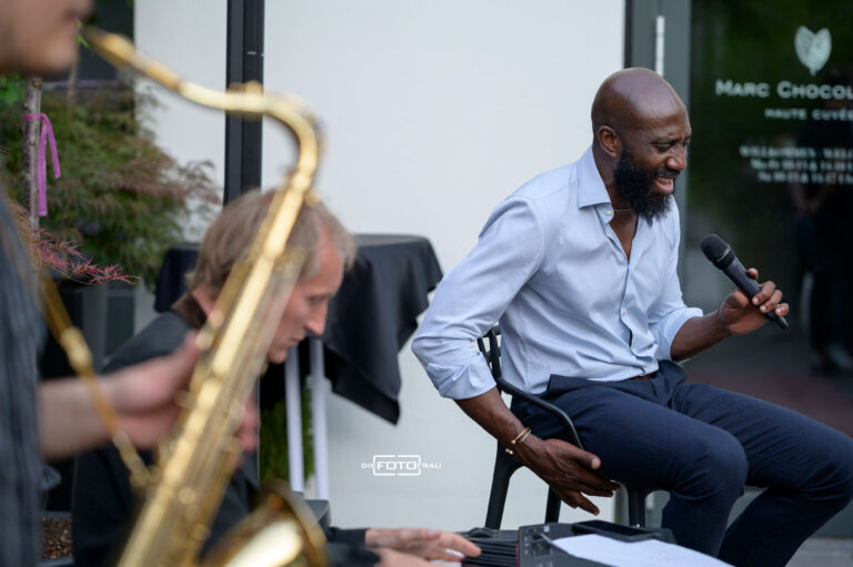 Schwarzer Musiker als Sänger und Saxophonspieler bei einem Jazzkonzert