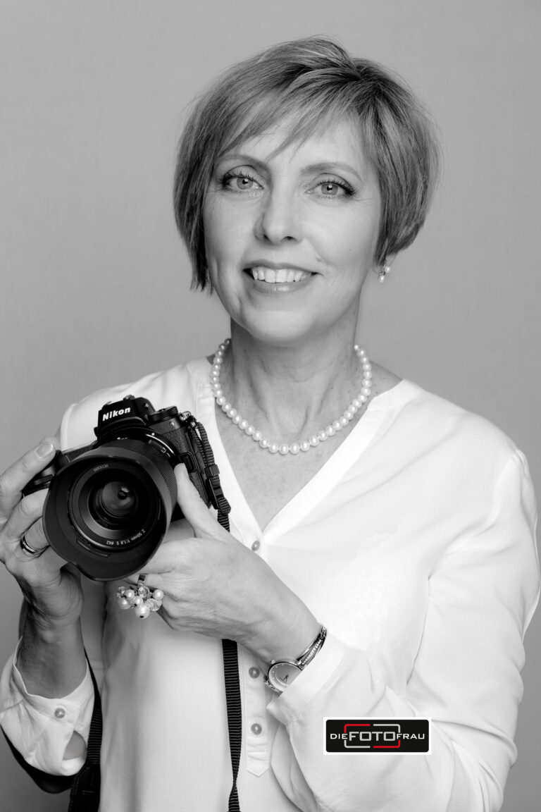 Fotografin mit Kamera in der Hand, schwarzweiss