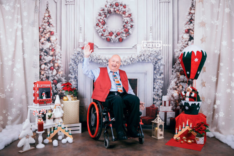 Rollstuhlfahrer in weihnachtlich dekoriertem Fotostudio in Linz