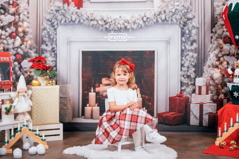 Kind in weihnachtlich dekoriertem Fotostudio in Linz