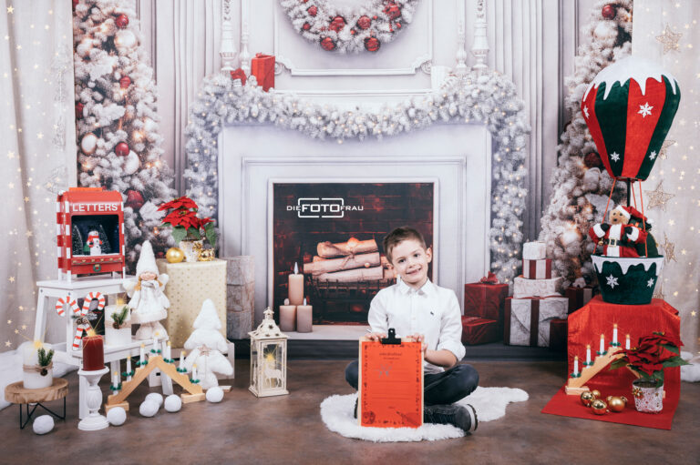 Kind in weihnachtlich dekoriertem Fotostudio in Linz