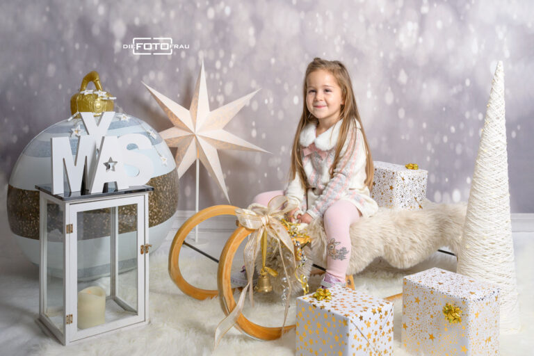 Kind in weihnachtlich dekoriertem Fotostudio in Linz
