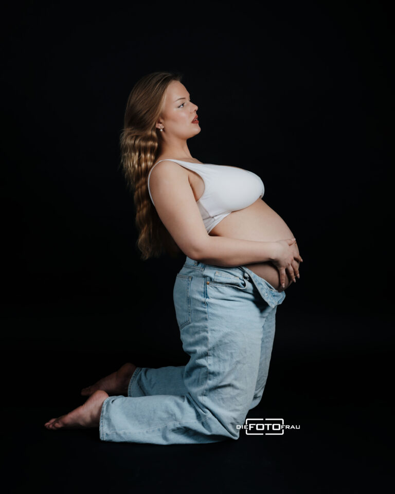 Schwangere Frau mit geöffneter Jeans, aufgenommen im Fotostudio DieFotoFrau